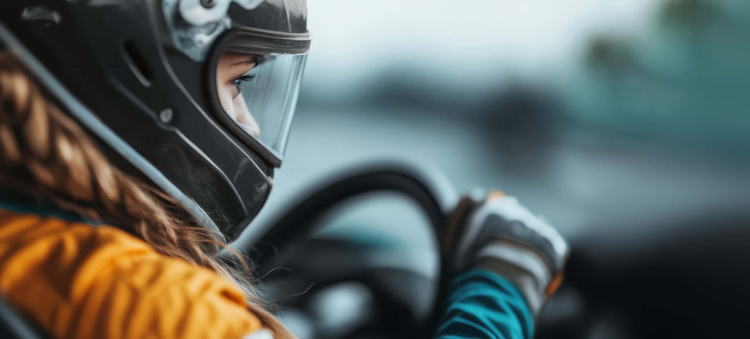 In this dynamic shot, a woman wearing a teal helmet and gloves